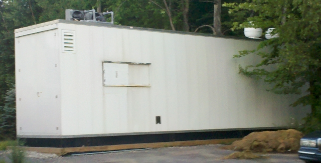 Plain, industrial looking portable building with digester inside